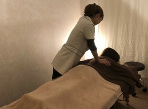施術台にうつ伏せになったお客様に、スタッフがボディケアを行っているl’pur by shimaの様子